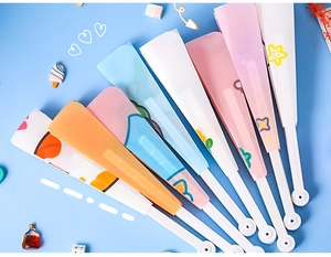 Flat lay of colorful cartoon folding fans on blue background with cute decorative props