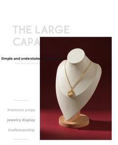 Detailed view of an 18K gold-plated teardrop pendant on a wooden portrait necklace stand