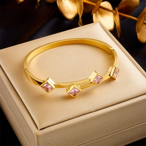 Luxurious gold titanium steel cuff bracelet featuring four square pink gemstone inlays