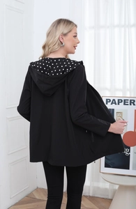 Detail of hooded jacket with polka dot lining and zip closure on the back and hood