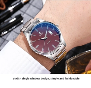 Close-up of men's business watch with burgundy dial and stainless steel strap on wrist