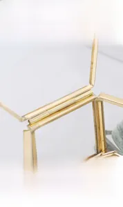 Detail of golden metal hinge and brass frame on glass jewelry box lid opening