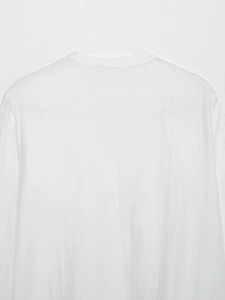 Vue arrière d'une chemise blanche à manches longues avec volants, suspendue sur cintre