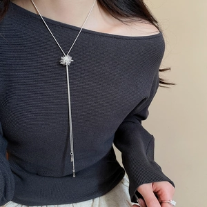 Detail of silver starburst pendant necklace and matching zircon ring on model