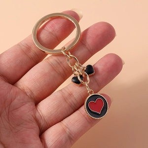 Detail of gold keychain with black heart charms and round red heart pendant