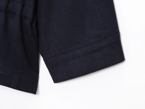 Detailed macro view showing the high-density linen blend fabric and double-stitched sleeve cuff