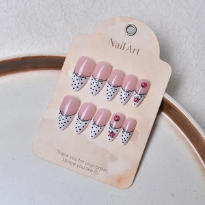 Detail view of handmade lavender press-on nails with bow lines and 3D ladybug charms