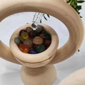 Detailed close-up of a glass dropper adding essential oil to natural crystals in a wooden diffuser