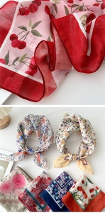 Detailed view of lightweight floral silk scarves with cherry and rose print patterns