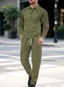 Male model wearing olive green textured polo shirt and cargo pants in urban street setting
