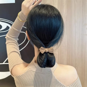 Detail of coffee brown bow hair tie with ribbed texture shown on a high ponytail