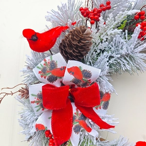 Christmas wreath with cedar branches, pine cones, red berries, and a cardinal bird detail