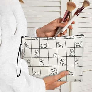 Portable checkered kitten makeup bag with canvas texture and zipper closure in hand