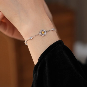 Detailed close-up of a silver compass star bracelet featuring a yellow zircon centerpiece