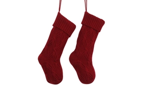 Close-up of red knitted Christmas stockings with hanging loops and diamond texture