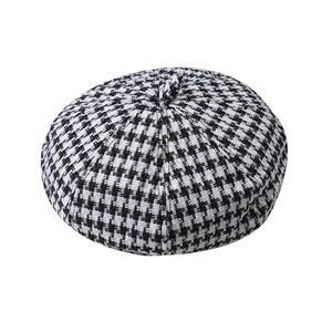 Detailed close-up of houndstooth wool beret texture and classic black and white weave