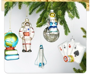 Detailed view of hand-painted glass astronaut and globe ornaments hanging on a Christmas tree