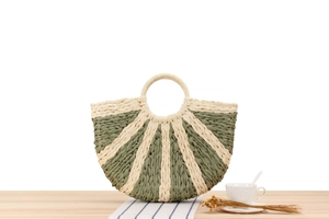 Detailed close-up of a semi-circular woven paper rope handbag with green stripes
