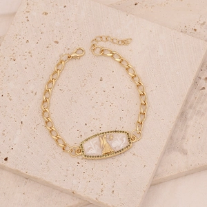 Detail of gold chain bracelet with goddess relief and green zircon stones on stone