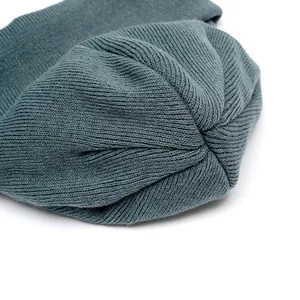 Deep grey-blue knitted beanie hat featuring reinforced top stitching for durability