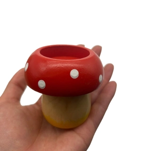 Handheld mushroom-shaped wooden candle holder with a red dotted cap for festive decor