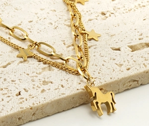 Détail du bracelet double couche en or 18k avec pendentifs étoile et licorne sur pierre