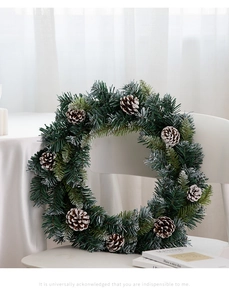 Makroaufnahme vom nordischen Weihnachtskranz mit Kiefernnadeln und beschneiten Tannenzapfen