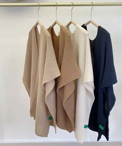 Detailed close-up of thick knit shawl texture and color variety in cozy cashmere style