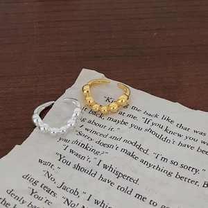 Macro detail of S925 sterling silver beaded open ring with hallmark on vintage paper