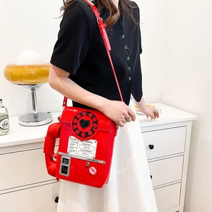 Detail of red telephone-shaped crossbody bag with 'Best Hotline' lettering and retro dial