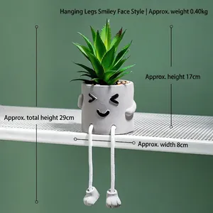Detailed view of artificial succulent in a cement pot with smiling face and hanging legs