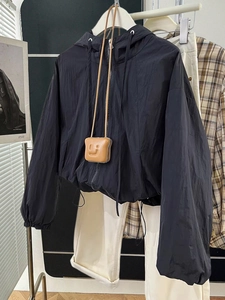 Detail of black lightweight zip-up windbreaker with drawstring hem and smiley bag