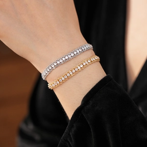 Macro detail of silver and gold plated tennis bracelets featuring triple row cubic zirconia
