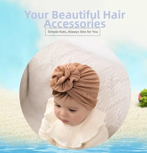Close-up of knit baby turban hat with large 3D floral decoration in earthy yellow tone