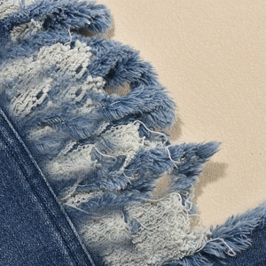 Gros plan du tissu denim bleu avec des franges usées et des textures délavées