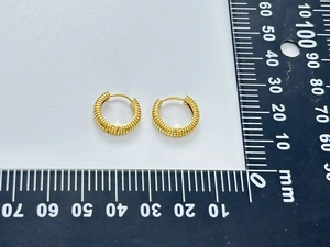 Close-up of 18K gold plated hoop earrings featuring a spiral texture and 20mm diameter