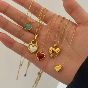 Close-up of five assorted heart-shaped 18K gold-plated necklaces with diverse gemstones