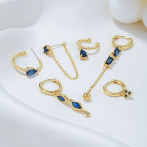 Elegant gold drop earrings set with dark blue zircon stones and long tassel chains
