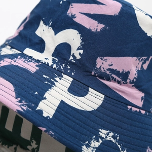 Detail of pink graffiti prints and stitching on a navy cotton bucket hat fabric