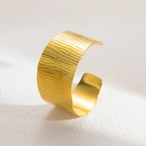 Detail of 18K gold plated wide open bangle with unique tree bark wood grain texture