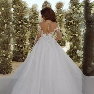Elegant white long sleeve ball gown wedding dress with floral lace and button back
