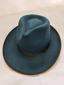 Close-up of a teal wool fedora hat with black ribbon band and decorative side bow