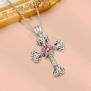 Detailed view of silver cross pendant with red gemstone on a vintage steel necklace