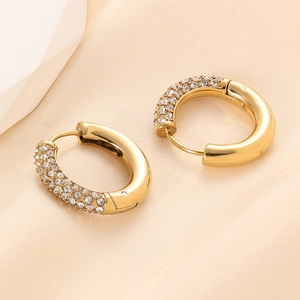 Macro detail of 14K gold plated C-shaped hoop earrings with sparkling white zircon stones