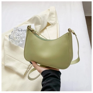 Detalle de bolso hobo de media luna verde claro en cuero PU y herrajes dorados