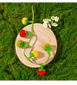 Handcrafted felt catnip toy with tomato and pumpkin shapes on a rustic wood base