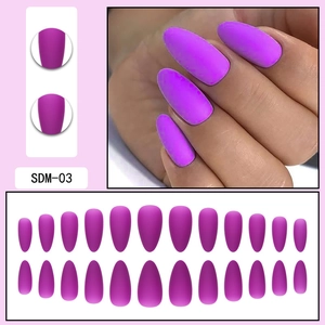 Macro detail of matte magenta press-on nails with 24 pieces of almond-shaped nail tips