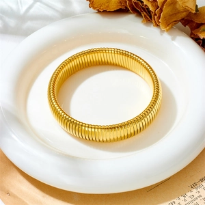 Vista macro de una pulsera Tubogas dorada sobre un expositor de estética vintage