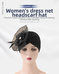 Detail of vintage black turban hat with mesh flower, feather accent, and white pearl bead