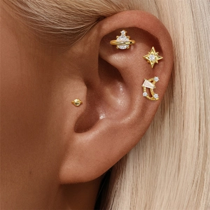 Detail of S925 silver gold earring set with star and pearl on model ear